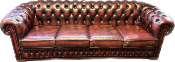 Chesterfield four seat settee, covered in a red leather button upholstery [220cm]