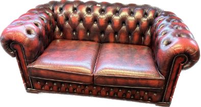 Chesterfield two seat settee, covered in a red leather button upholstery