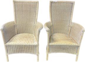Two wicker high back arm chairs