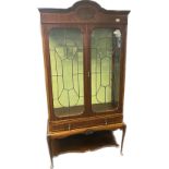 Edwardian display unit, the moulded shaped cornice above two glazed doors opening to glass shelved