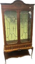 Edwardian display unit, the moulded shaped cornice above two glazed doors opening to glass shelved