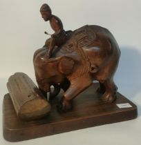 Genuine Burma Teak elephant & rider sculpture pushing a tree trunk supported on a wooden plinth [