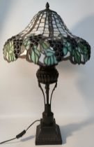 Tiffany grape fruit shaded table lamp supported on a cast metal base