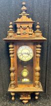 Antique style wall clock with pendulum within a mahogany casing