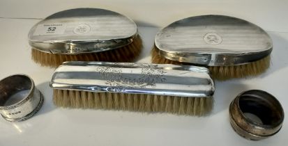 Three silver hallmarked backed brushes, Birmingham, together with two silver napkin rings