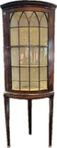Edwardian bow front corner unit, the moulded cornice over an astragal glazed door, raised on