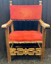 19th century oak chair, the back and seat covered in a red upholstery and flanked by open scroll