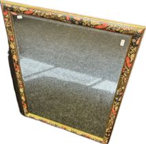 Antique style bevel edge mirror within a blackened frame with floral design