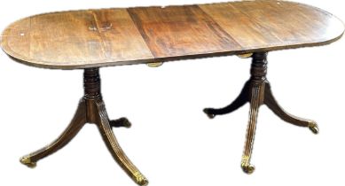19th century twin pedestal table, with rounded ends, ringed columns, the tripod legs with brass caps