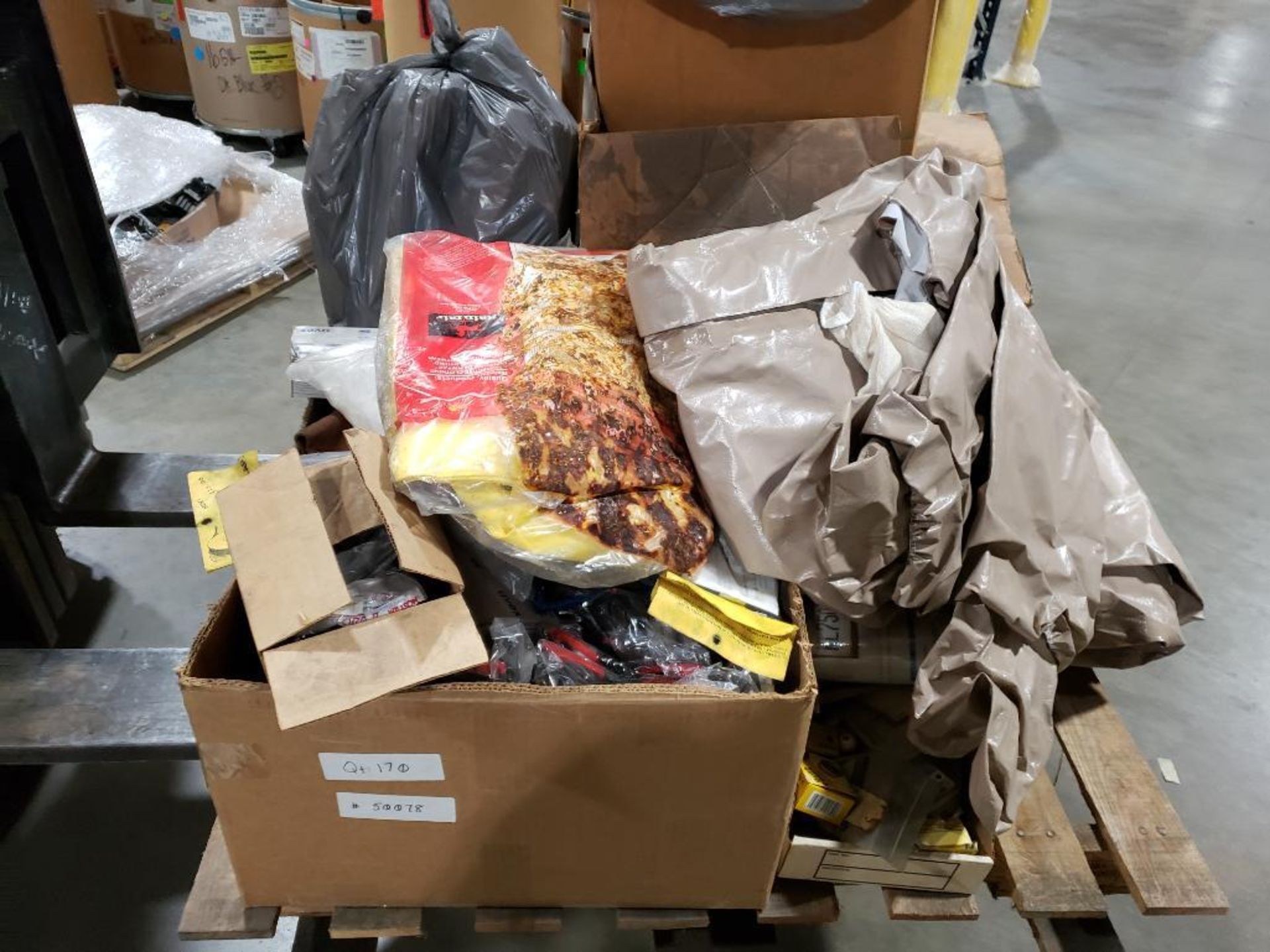 Pallet of assorted tarps, safety goggles, and other parts.