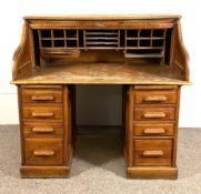 A late Victorian oak tambour front desk, with multiple pigeon holes and drawers