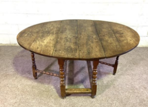 An oak gateleg table, early 18th century, English provincial, with a large planked plain oval drop