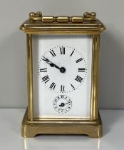 A brass cased carriage alarm clock, with four glass case, the enamel dial with subsidiary alarm