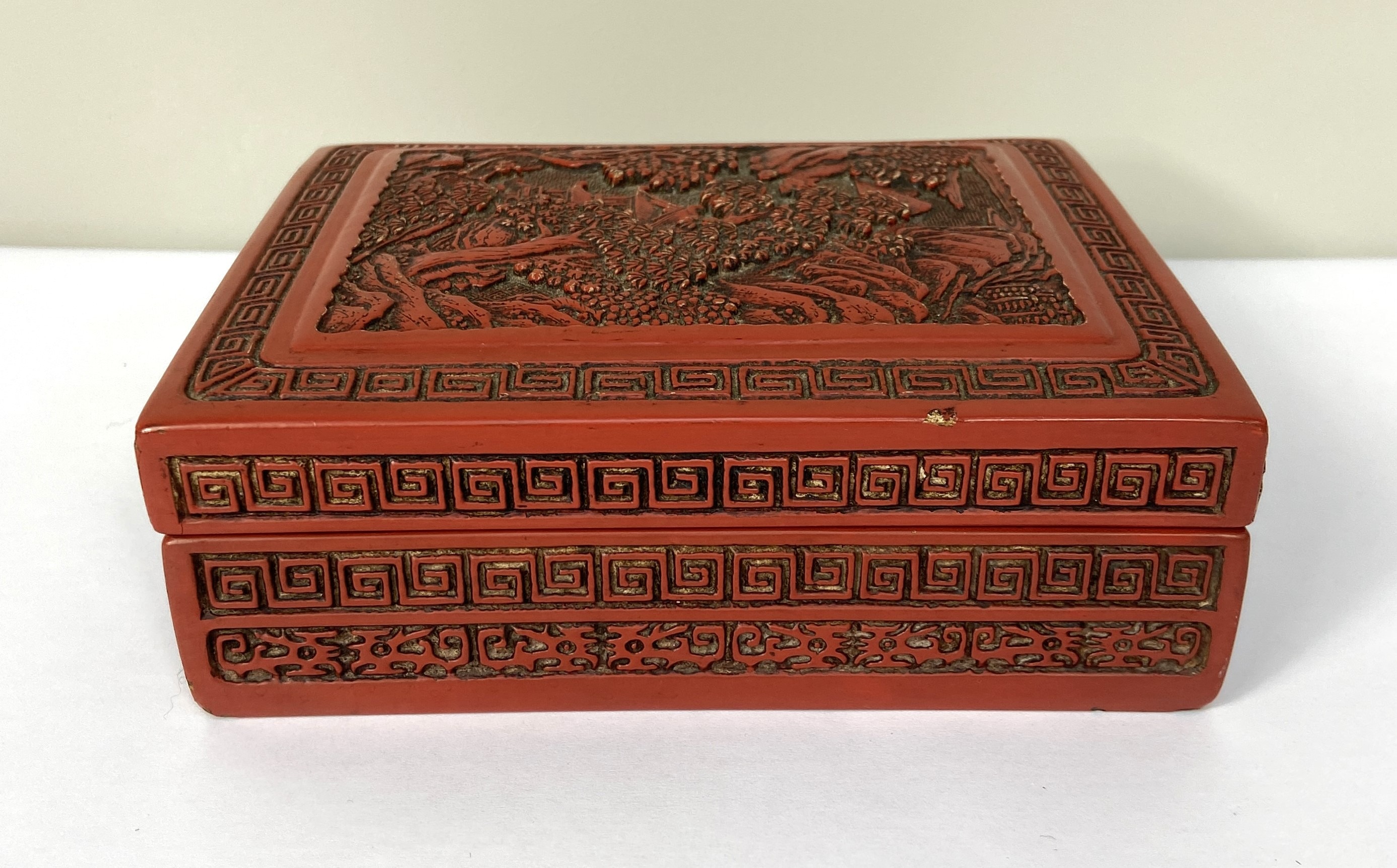 A Chinese export Cinnabar lacquered trinket box, 20th century, the top decorated with a tree lined