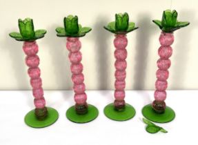 A set of four cranberry and green glass knopped candlesticks, 30cm high