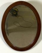 Four assorted modern mirrors, including a pine framed arched top wall mirror; an oval wall mirror