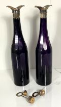 A pair of Georgian amethyst glass bottle decanters, circa 1800-1820, each with a tall round body and