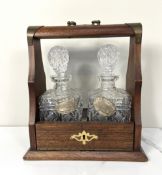 A small vintage Tantalus, set with two decanters and plated spirit labels