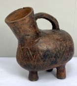 A large pottery vessel with sgraffito decoration and three feet, possibly African Tribal, 29cm high,