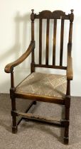 A vintage Jacobean style beech wood framed armchair