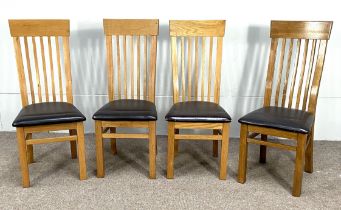 A set of four Modern ash wood framed stick backed dining chairs, with 'leather' seat squabs and