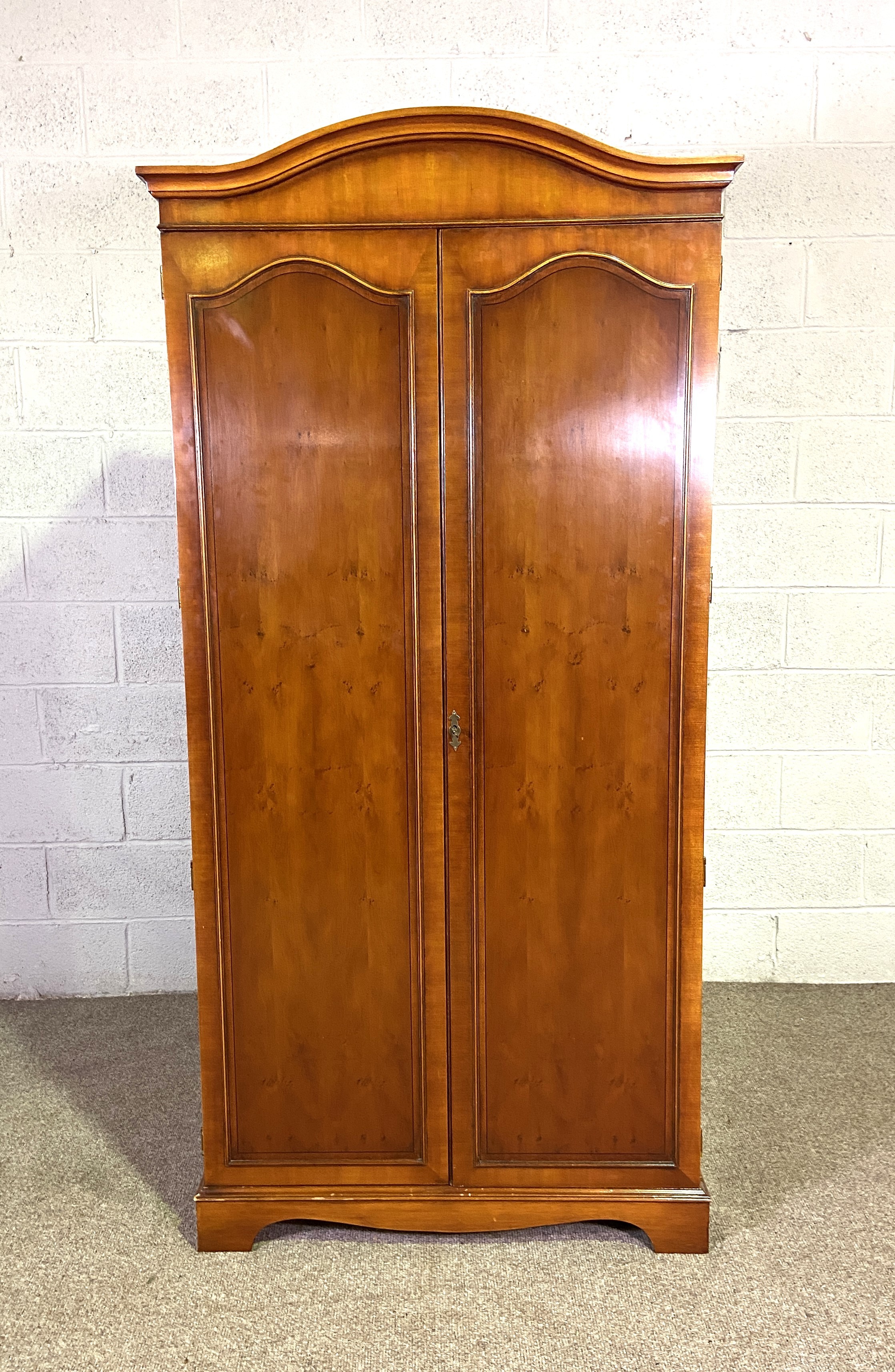 A Georgian reproduction two door wardrobe, with arched top