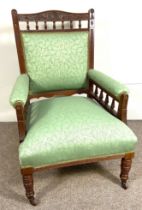 A late Victorian Gentleman's easy armchair, with bobbin turned and padded back and arms, turned legs