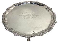 A silver presentation salver, hallmarked London 1930, with guilloche and anthemion border, set on