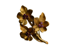 An 18 carat gold and ruby leaf brooch,  hallmarked 750, with a spray of three naturalistic leaves,