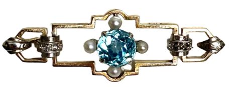 An Aquamarine and Seed Pearl brooch, 9 carat gold,  with a 7mm round cut stone flanked by four small