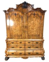 An impressive Dutch walnut armoire, early 19th century,  with an arched and moulded cornice, centred