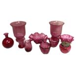 A collection of cranberry glass, including two storm lantern style vases, a pair of lobed small