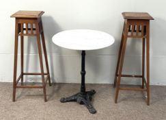 A pair on oak Arts & Crafts style torcheres/ plant stands, with square tops and tapered angled legs;