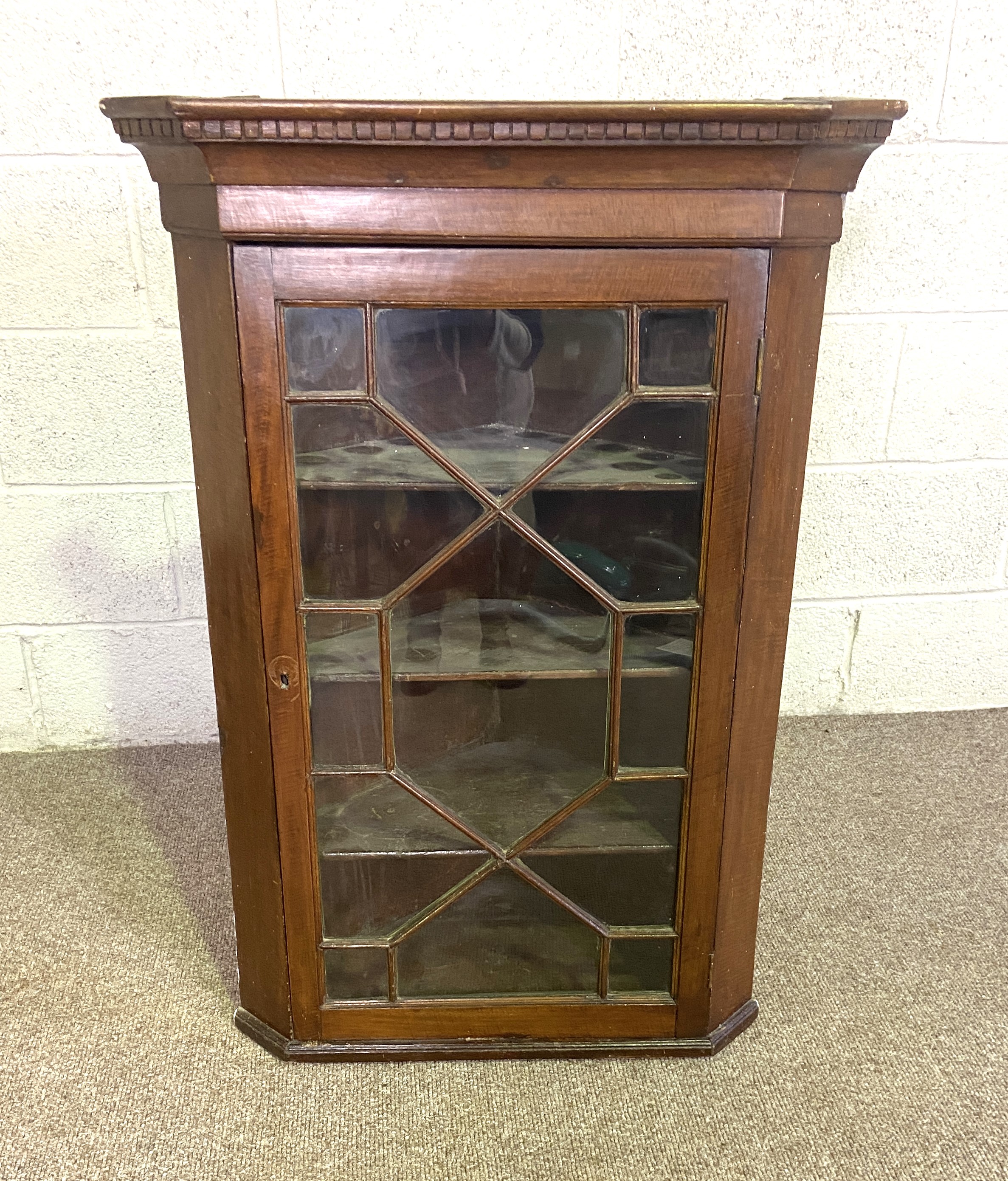 A George III style oak corner wall cabinet, with glazed door, dentil cornice and three shelves,