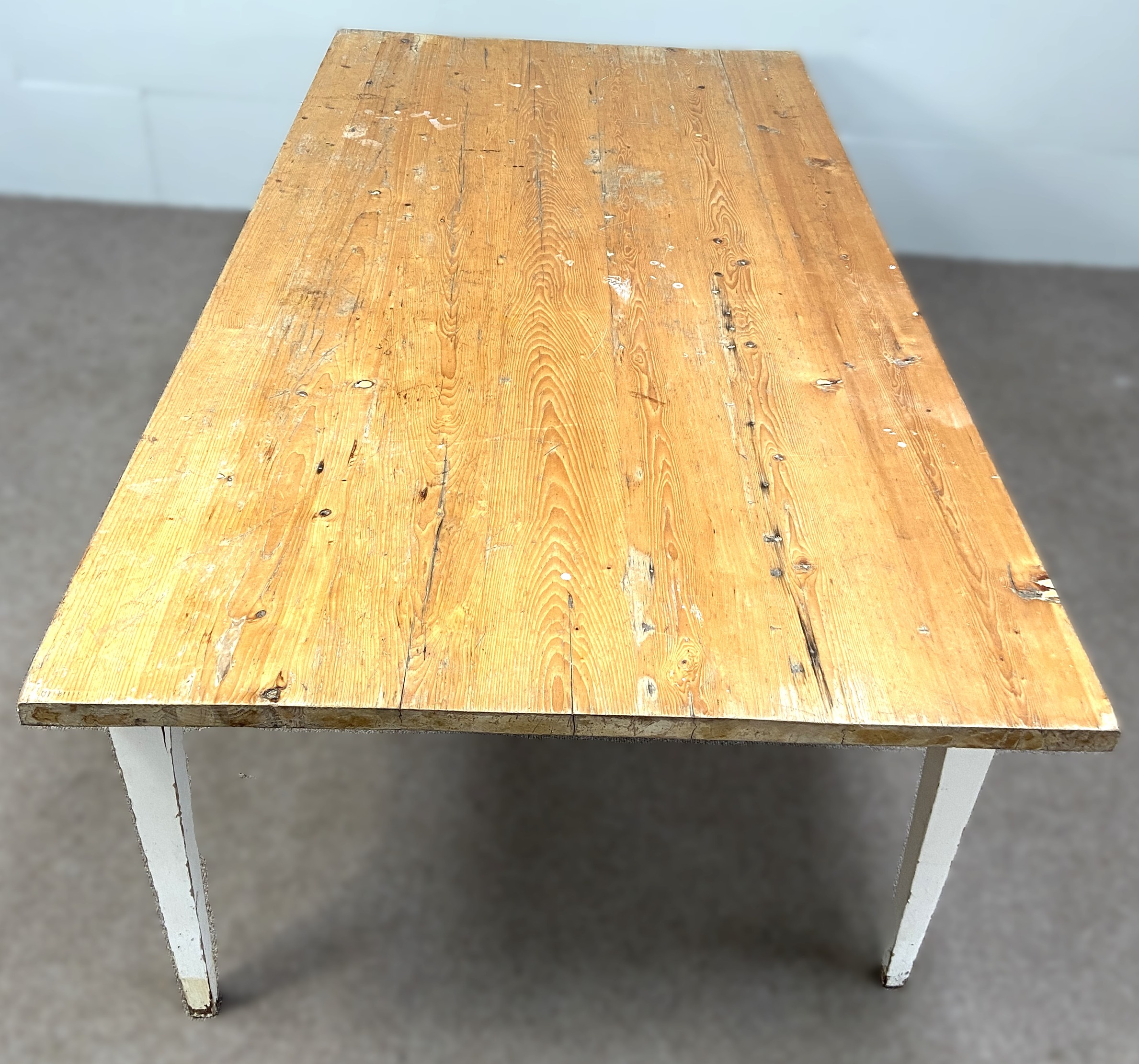 A large vintage stripped pine and white painted kitchen table, with rectangular top and four tapered