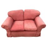 A modern two seater sofa, with padded back and cushions, currently upholstered in red cotton damask