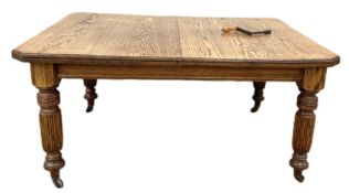 A late Victorian oak extending dining tables, with four turned and reeded legs, two leaves, and