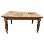 A late Victorian oak extending dining tables, with four turned and reeded legs, two leaves, and