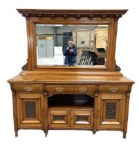 A late Victorian oak sideboard, with mirrored back over three concave fronted frieze drawers over