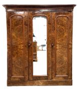 A mid Victorian burr walnut veneered triple wardrobe, circa 1870, with a central arch moulded