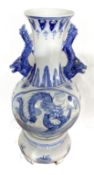 A Chinese blue and white vase and matching base, modern, decorated in underglaze glue with Dragons