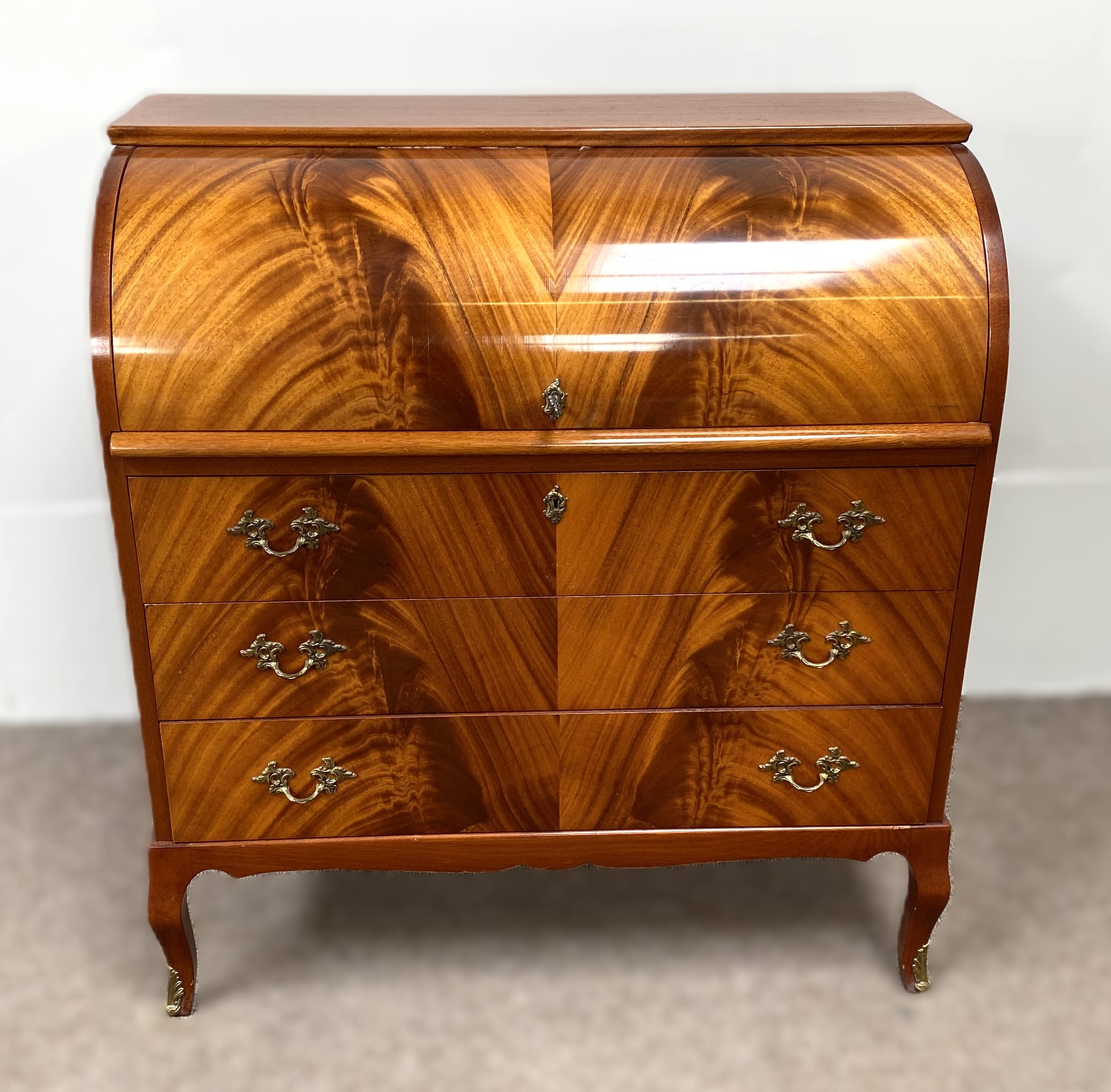 A modern reproduction mahogany veneered cylinder bureau, with roll top and arrangement of niches and