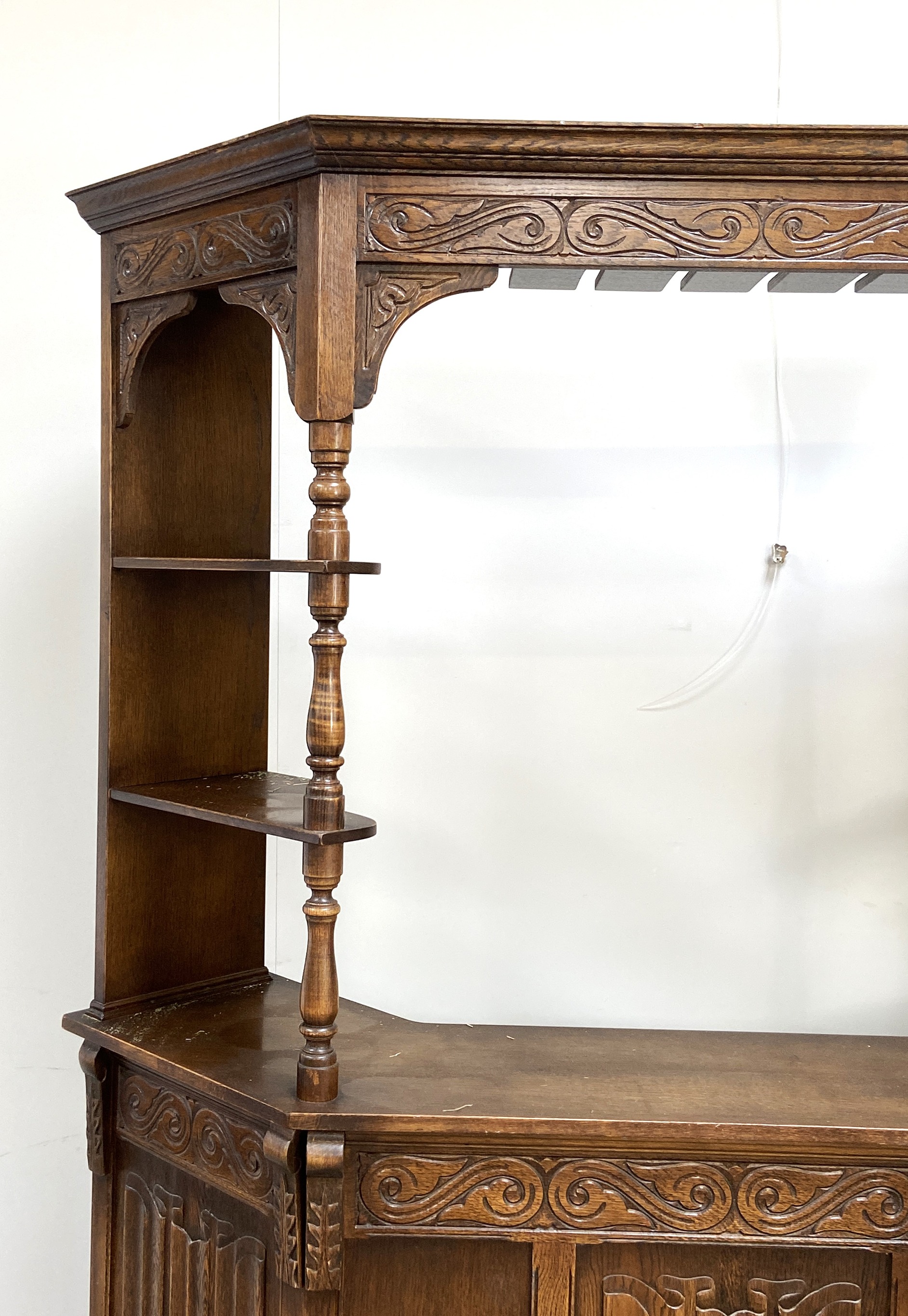 A vintage oak Jacobean style bar, mid 20th century, with canted sides and arched cornice over the - Image 2 of 5