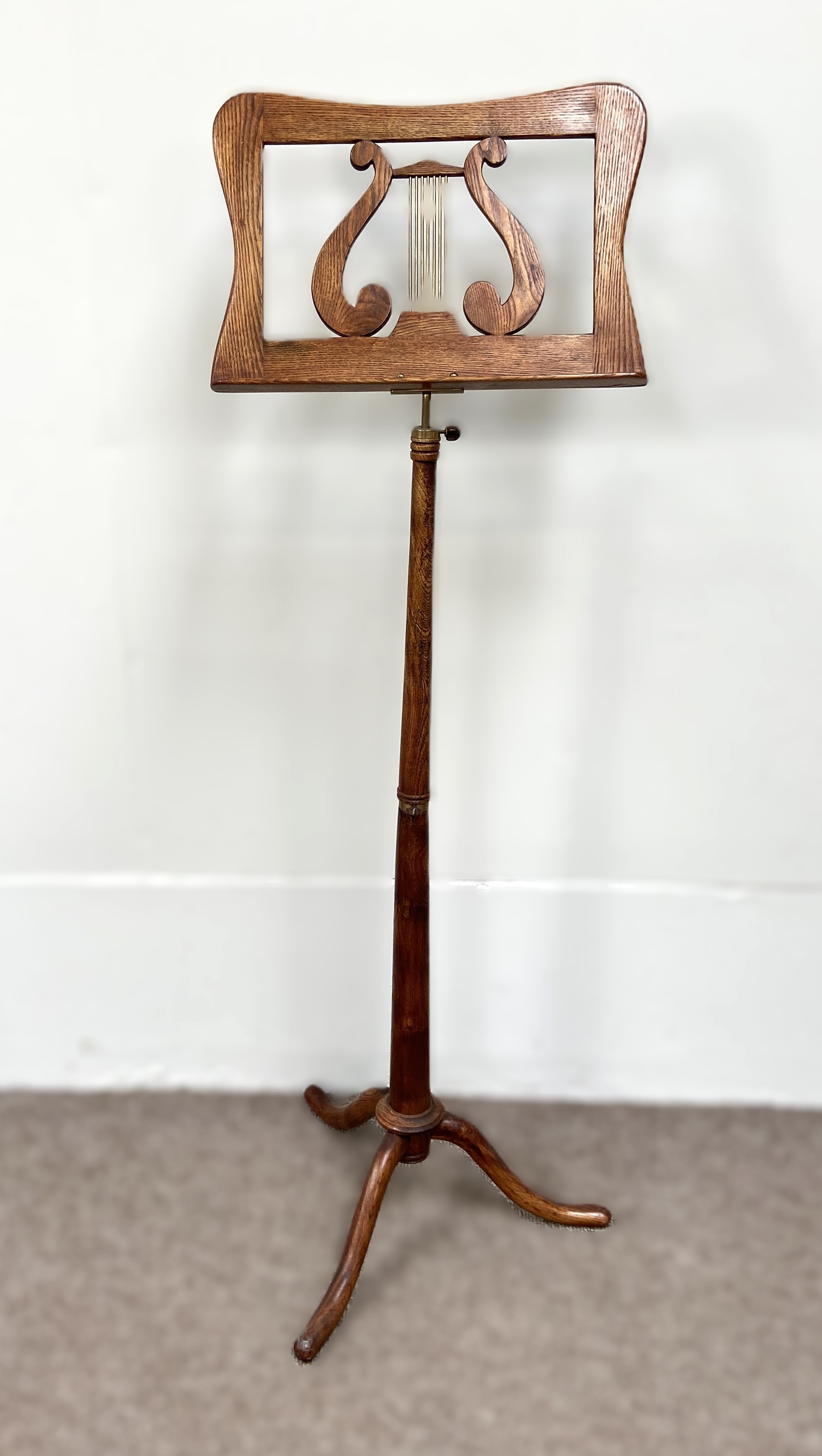 A Regency style oak framed music stand, 20th century, with adjustable ring turned pillar, surmounted