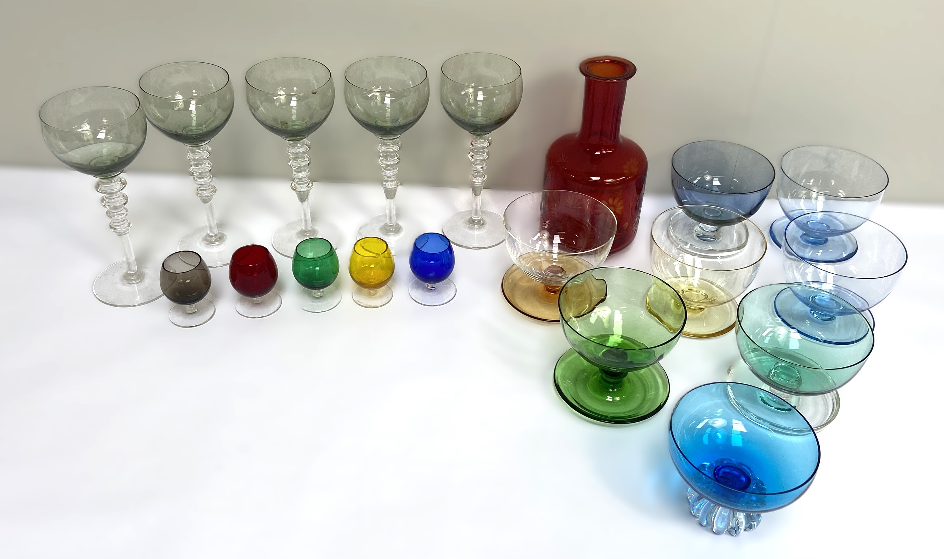 A selection of coloured glassware, including a ruby glass mallet decanter, goblets and a set of