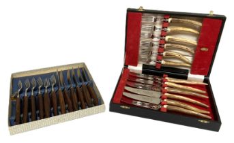 A set of six pairs of horn handled knives and forks, cased; together with another cutlery set (2)