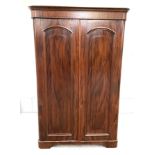 A Victorian mahogany compactum wardrobe, with moulded cornice, over two arched and panelled wardrobe