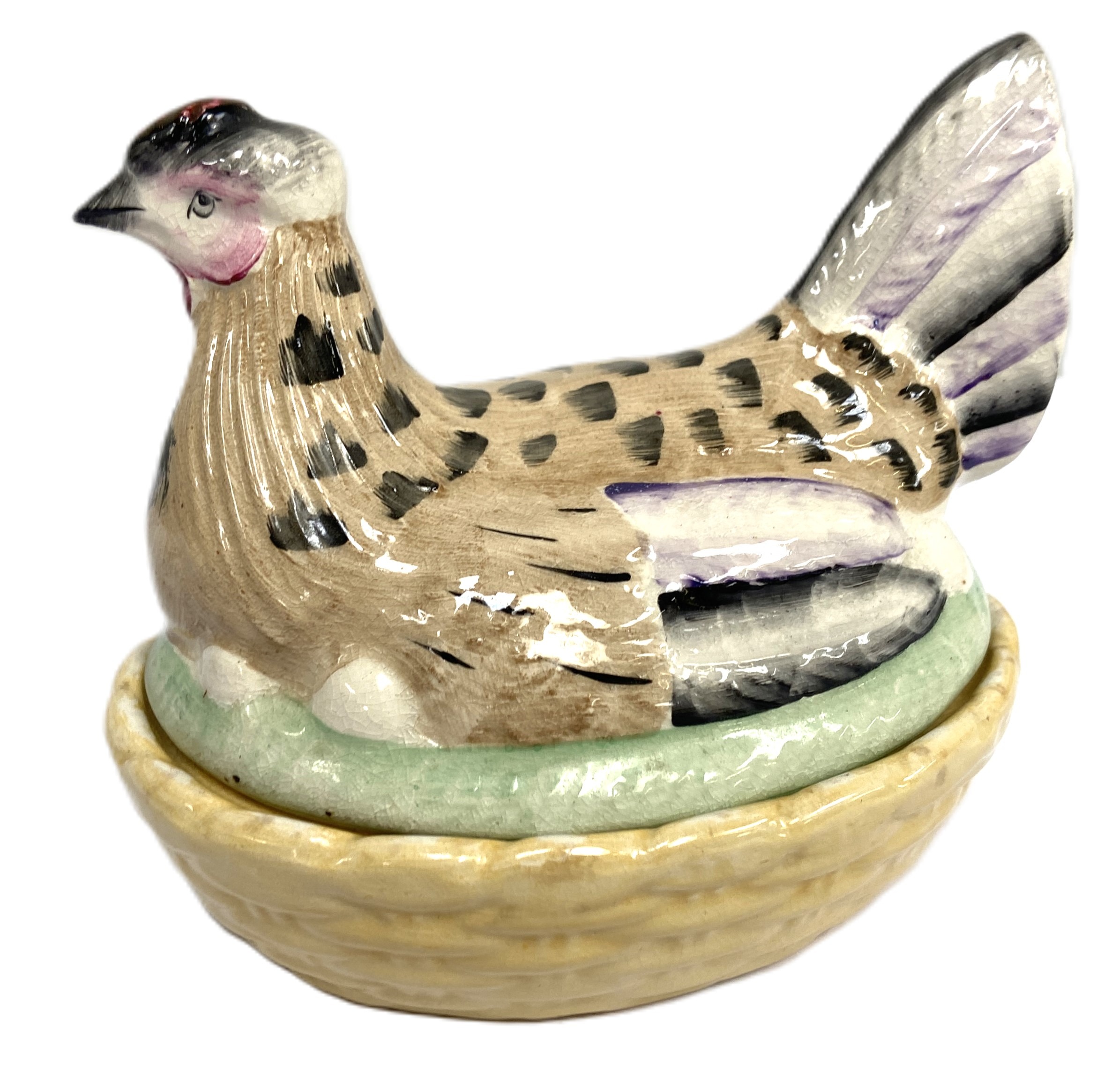 An assortment of ceramics, including a pottery chicken dish, a decorative glass dump, two mugs