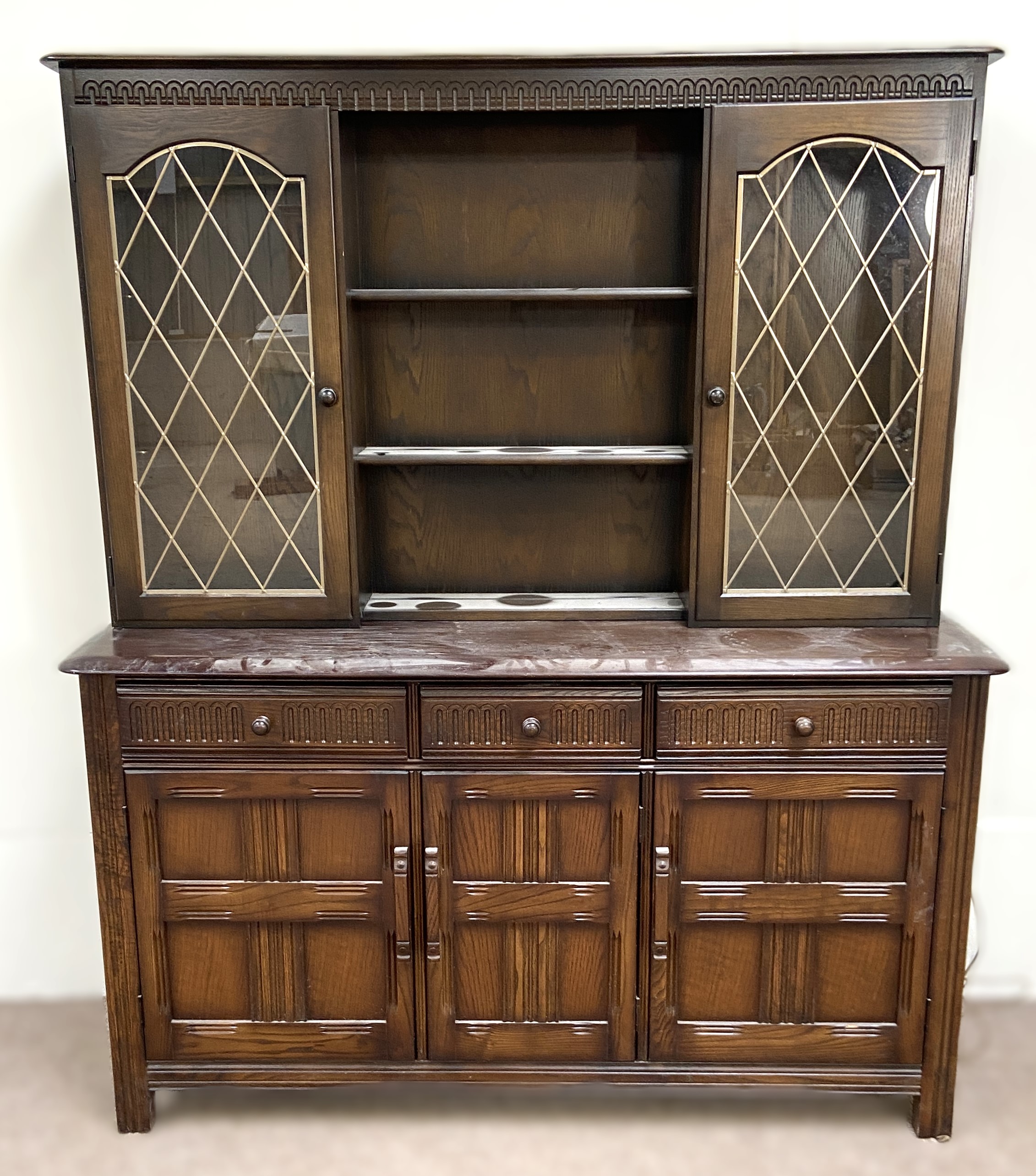 A vintage oak Jacobean style dresser, 20th century, the top with glazed cabinets and pot shelves,