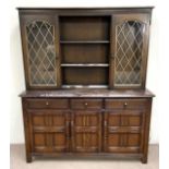 A vintage oak Jacobean style dresser, 20th century, the top with glazed cabinets and pot shelves,